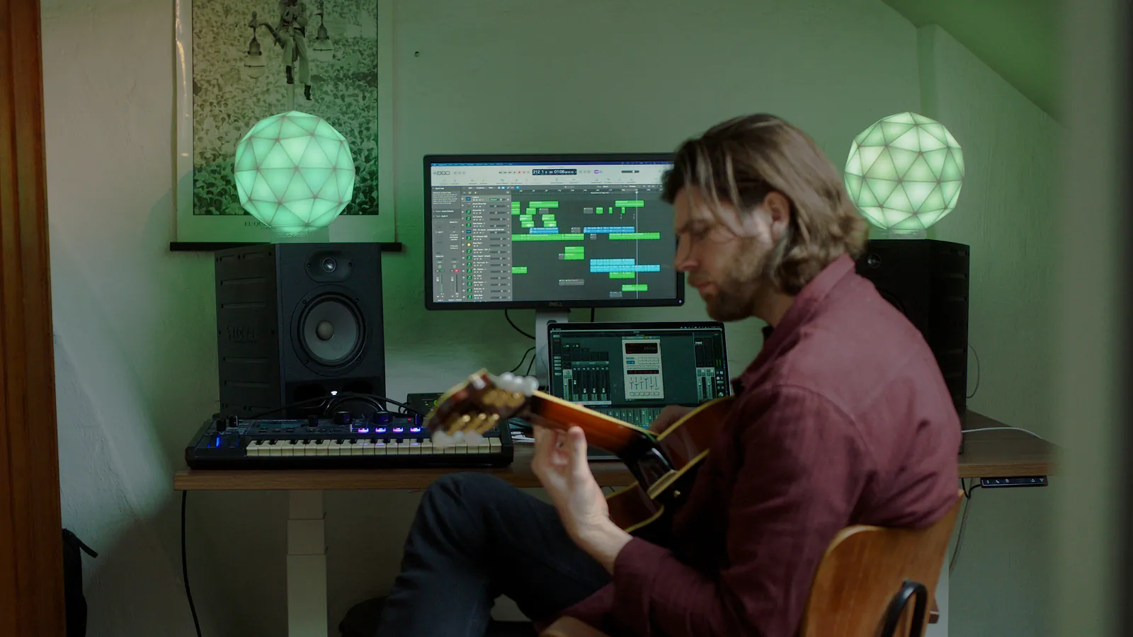 Zwei grün leuchtende GLORBs in einem Musikstudio, davor ein Mann mit Gitarre