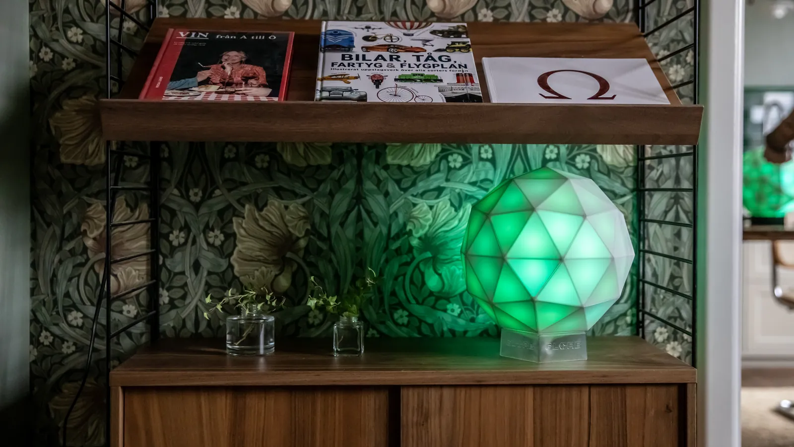 Eine grün leuchtende GLORB auf einem Sideboard im Wohnzimmer
